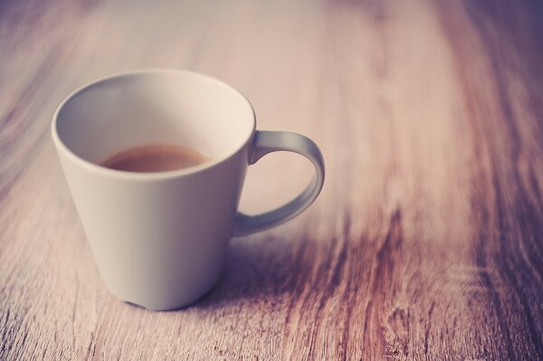 Kaffee auf der Unterseite der Tasse auf einem Holztisch