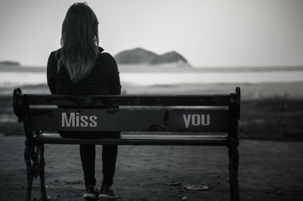 A lonely girl is sitting on a bench