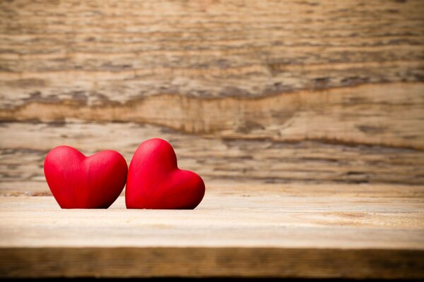 Dos corazones rojos en un soporte de madera