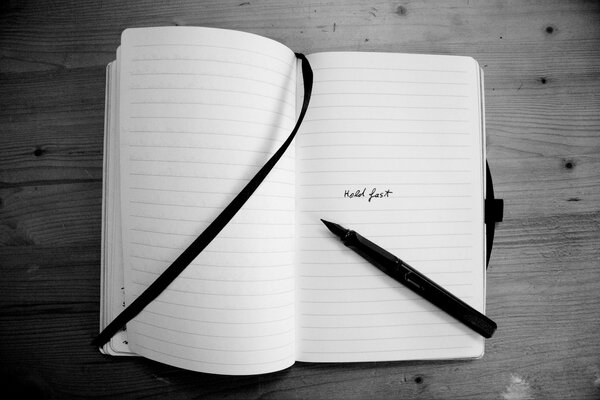 A black-and-white notebook. Notepad with a bookmark