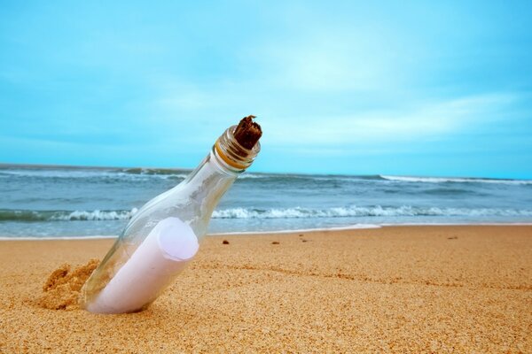 A bottle with a note washed up on a sandy beach