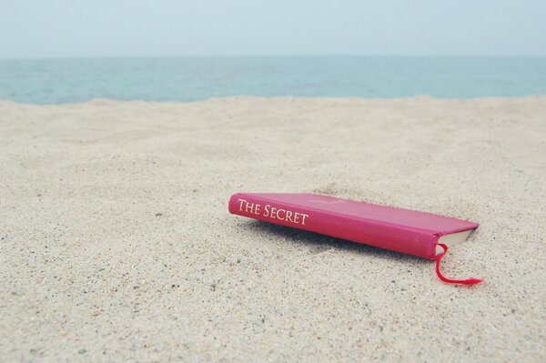 Libro en una playa de arena desierta