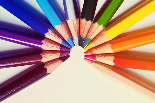 Multicolored pencils lie in the colors of the rainbow