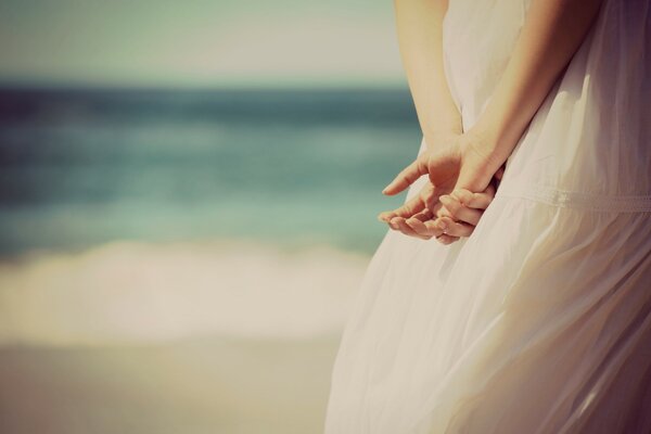 The girl in the dress put her hands behind her back