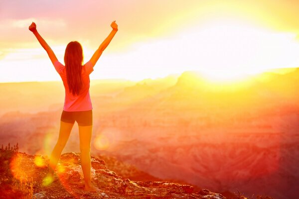 Ragazza sportiva libera che saluta il sole