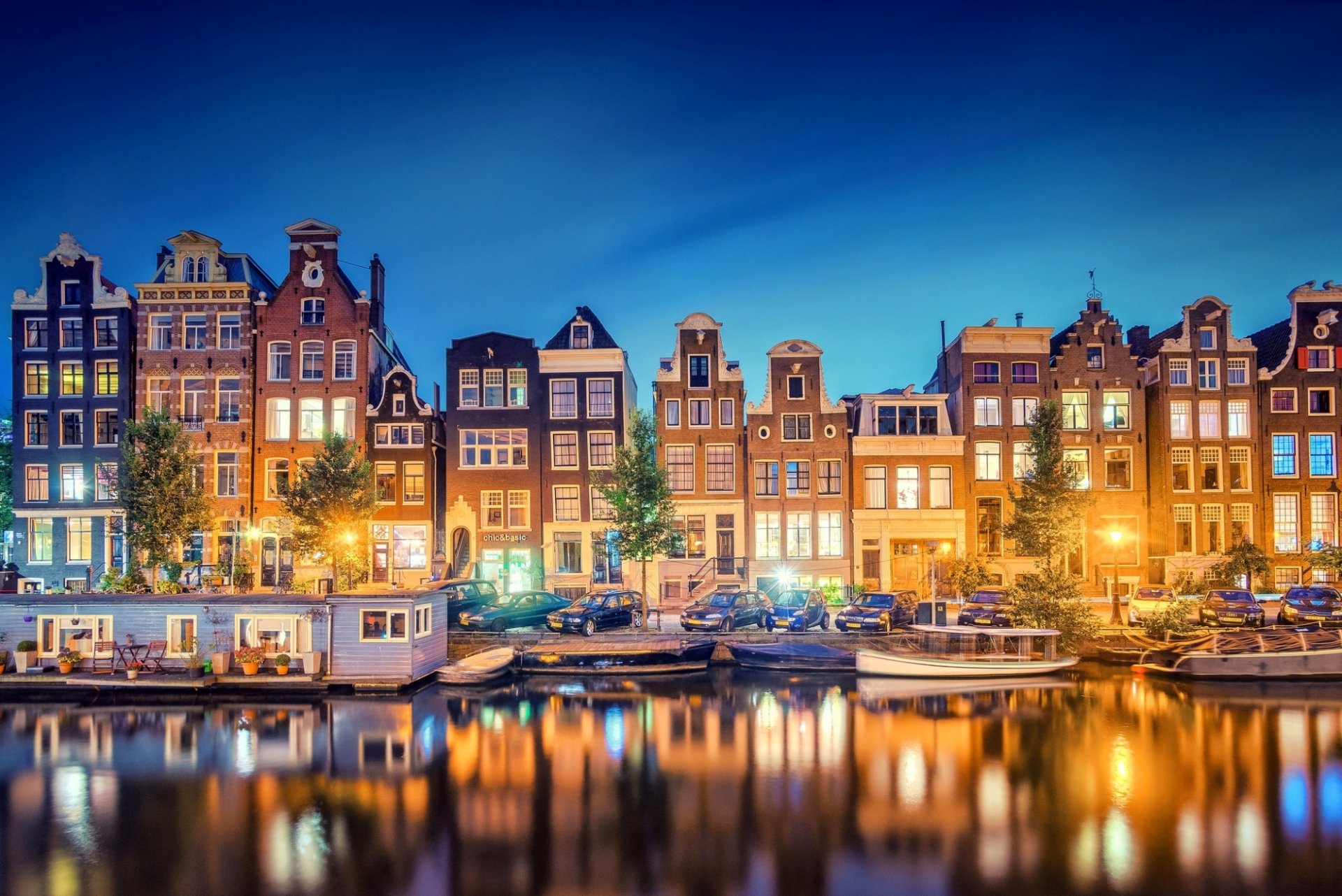 amsterdam olanda settentrionale olanda paesi bassi città sera canale luci riflessione luce barche fiume case edifici