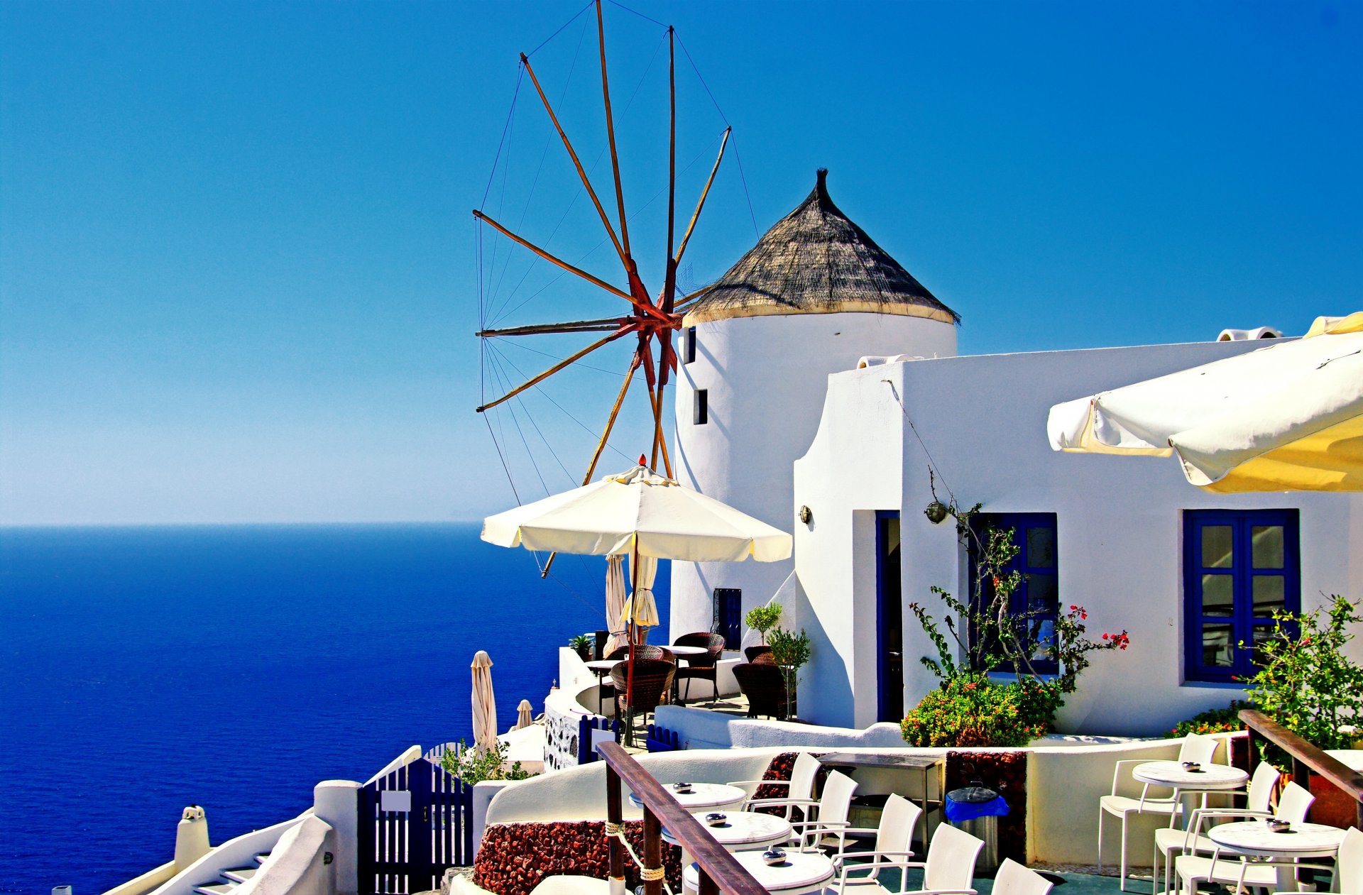 grecia oia santorini ciudad molino de viento casa mesas sillas sombrillas mar naturaleza