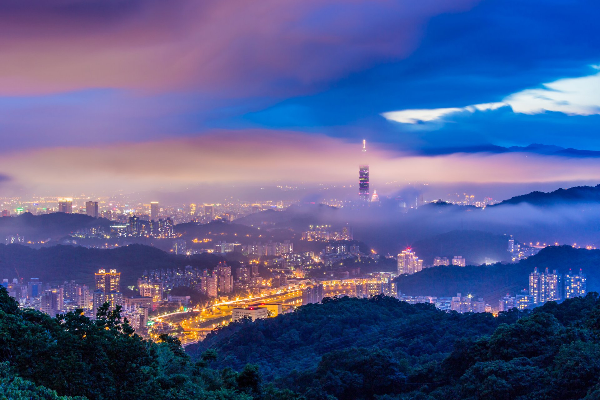 china taiwan taipeh stadt abend dämmerung berge hügel bäume dunst nebel blau himmel wolken gewitter turm gebäude häuser lichter beleuchtung ansicht höhe panorama