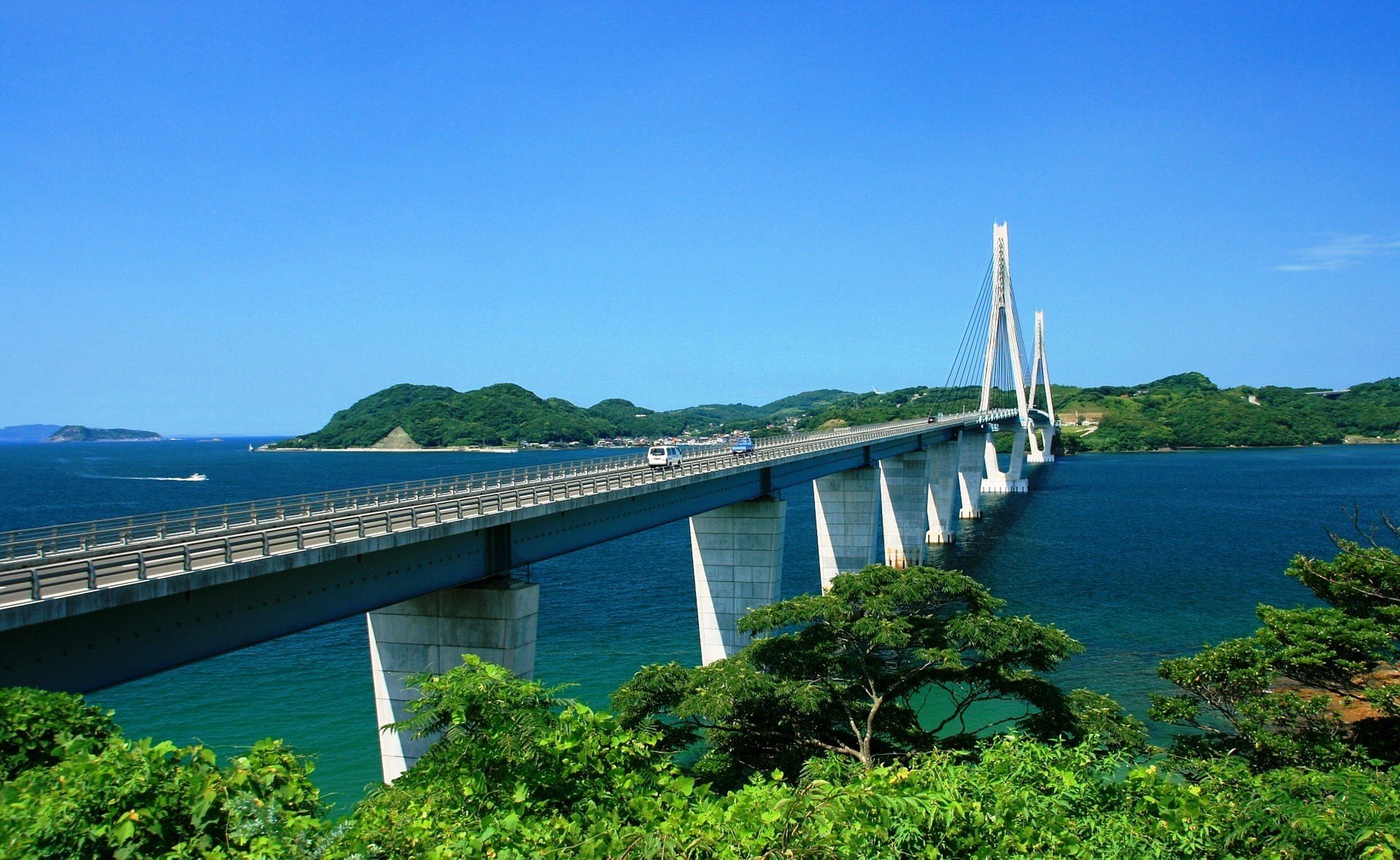 town country bridge river green plants nature tree blue sea the distance mountain sky