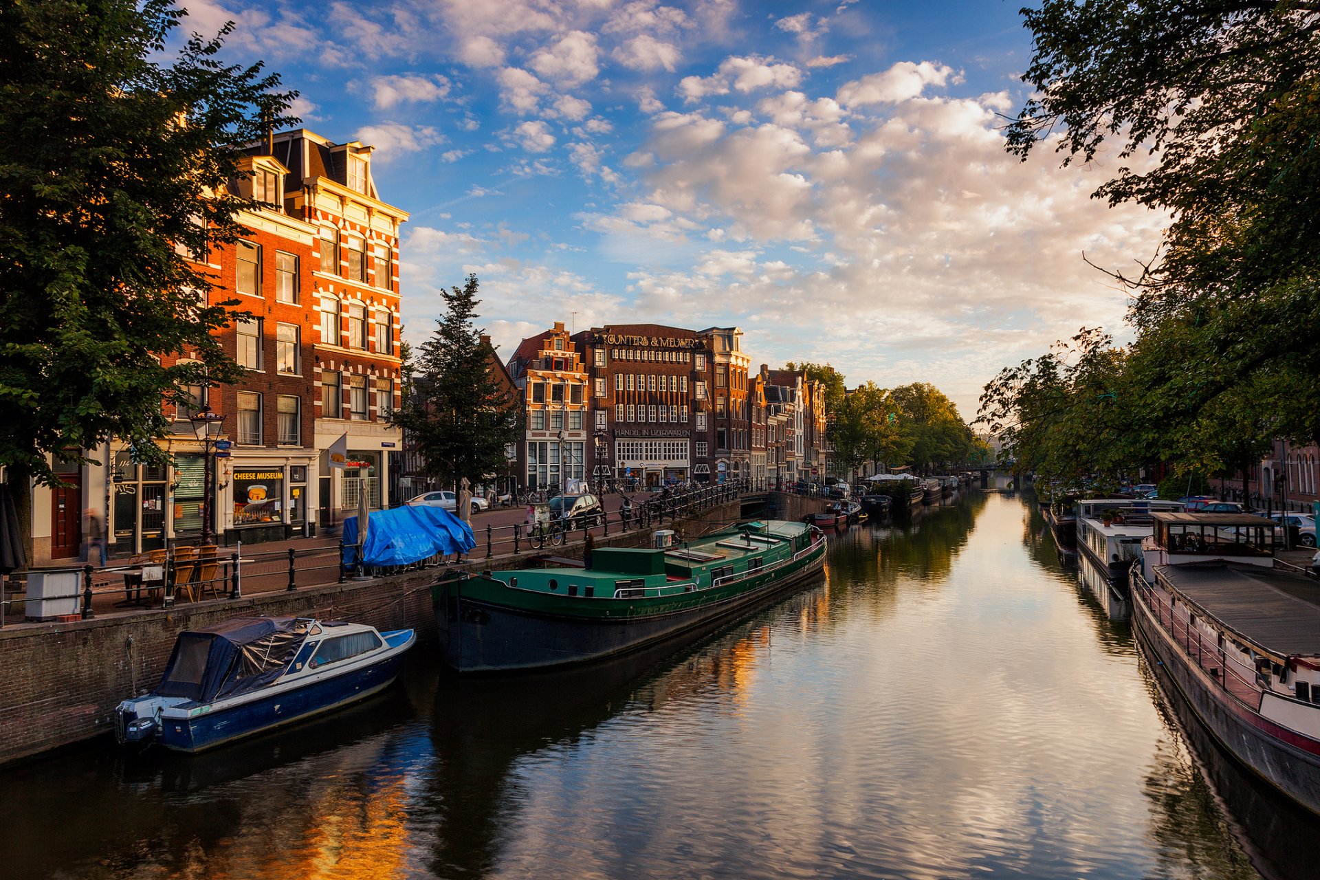 amsterdam holandia kanał rzeka woda łodzie domy budynki miasto wieczór niebo