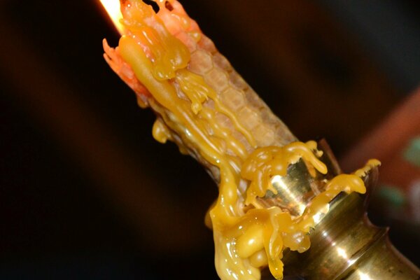 From a burning candle, drops of wax are dripping 8