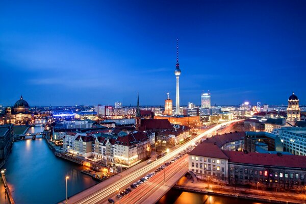 Panorama nocturne de Berlin avec le pont sur la Tamise et les maisons avec la tour de télévision en arrière-plan