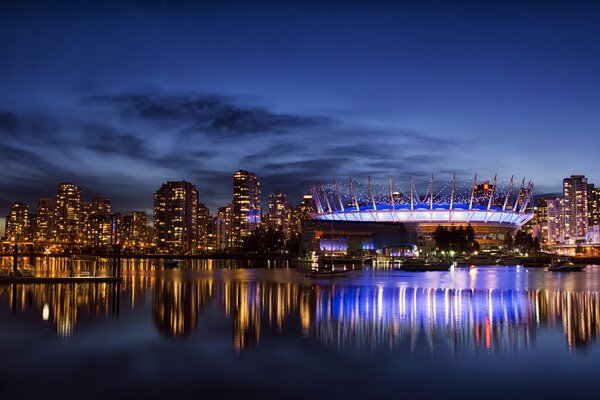 View of the night city. Reflection of the city in the water