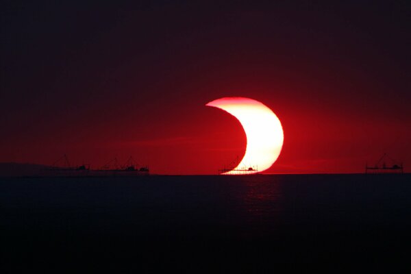 Solar eclipse on the background of the ocean and ships