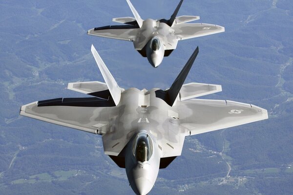 Un par de aviones Raptor f 22 vuelan por el cielo