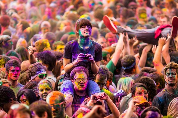 Радостные лица людей на фестивале красок