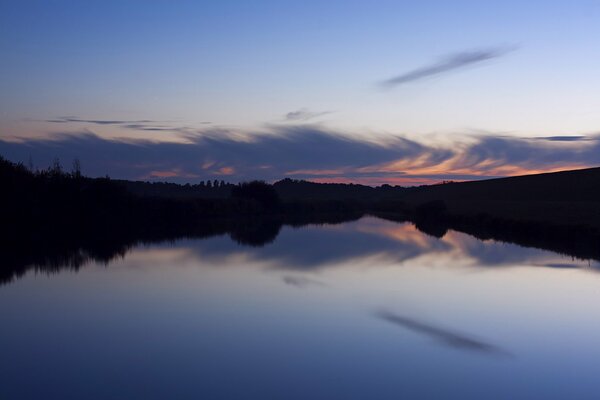 Puesta de sol por la tarde sobre el bosque y el lago