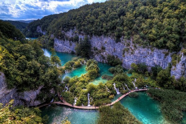 A bridge in the mountains over blue water