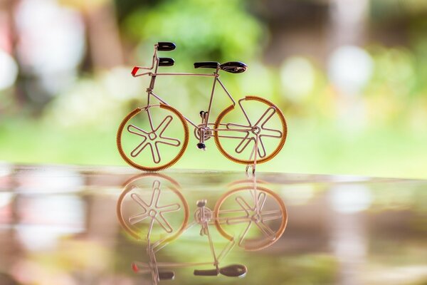 A toy bicycle is reflected in the glossy surface of the countertop