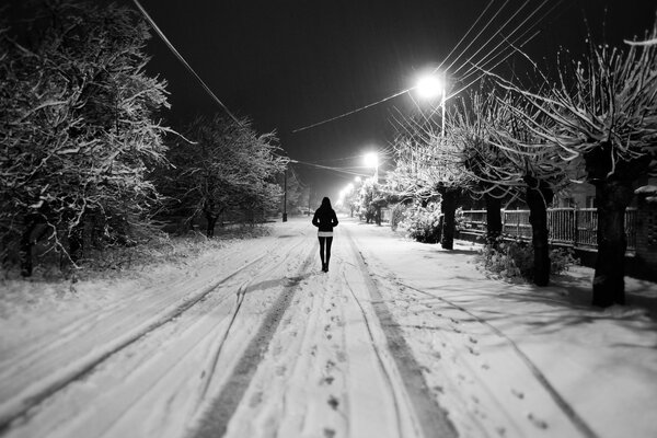 Paseo nocturno de la niña por la ciudad nocturna de invierno