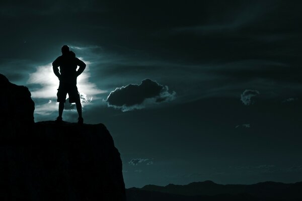 Ciel nocturne et homme sur le rebord de la montagne