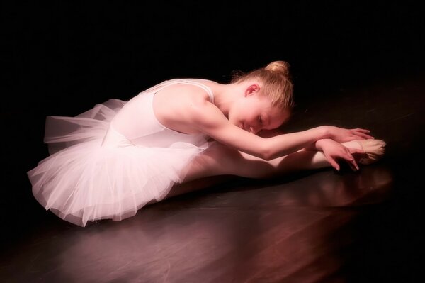 A young ballerina in pointe shoes is lonely