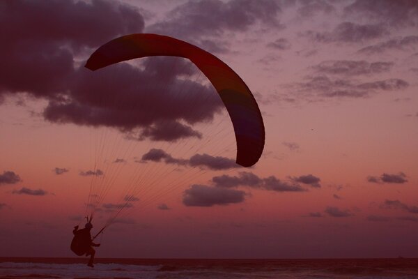 Paraglider on the background of a pink sunset sky