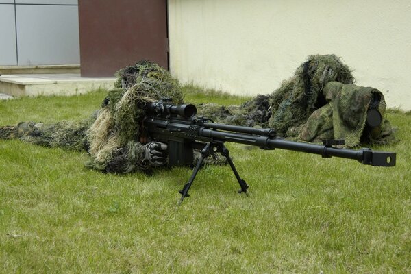 Militar con rifle de francotirador en la hierba