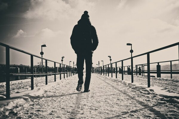 L homme marche sur la route en regardant en arrière. Male