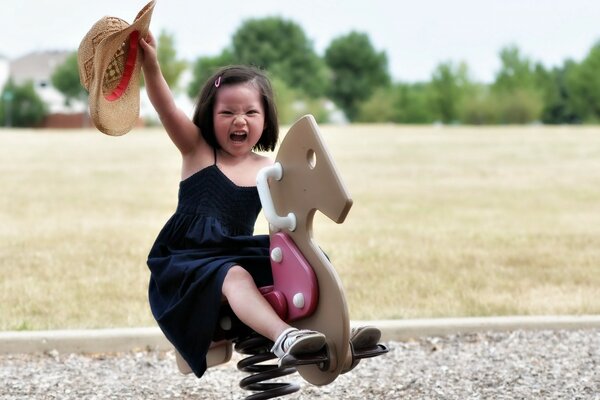 Bambina seduta su un cavallo giocattolo