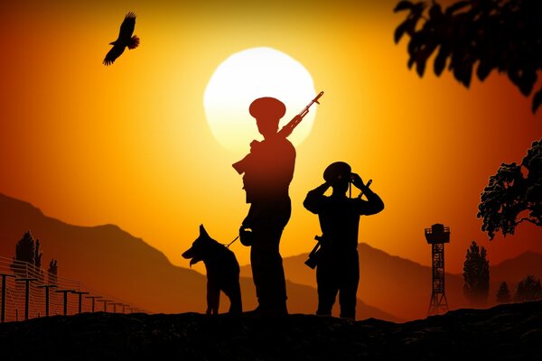 Guardias fronterizos con un perro al atardecer