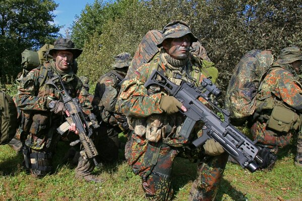 Verborgene Soldaten im Gebüsch mit Waffen