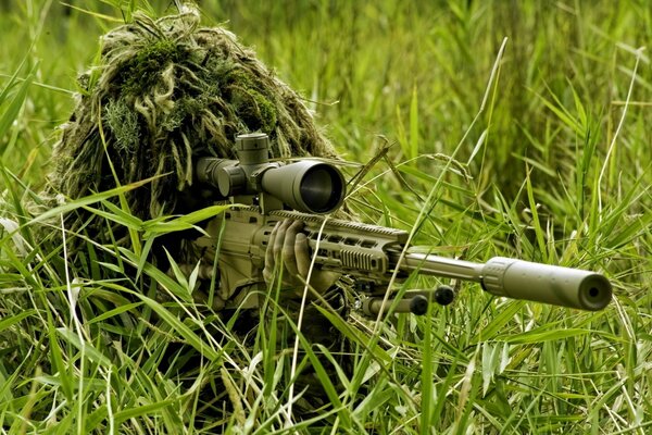 A military man in camouflage hid with a rifle