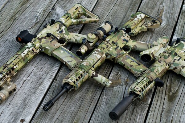 Khaki machine guns on a wooden background