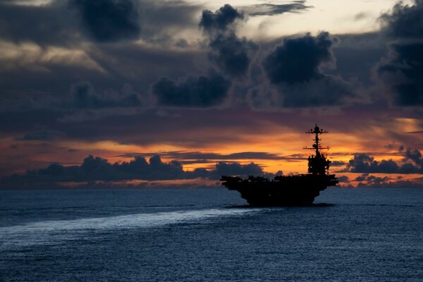 Porte-avions en mer pendant un beau coucher de soleil