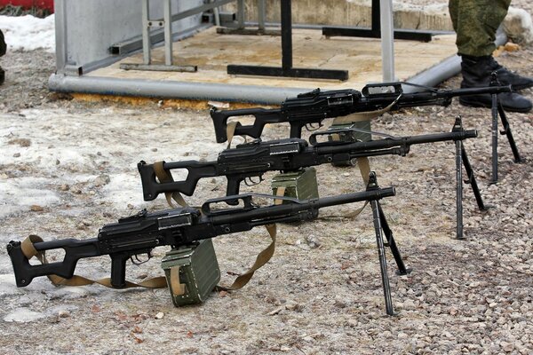 Three rifles mounted on gravel