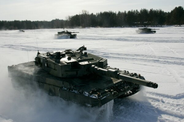 Tanks are driving through a snowy field