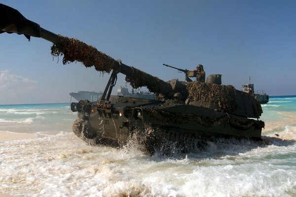 Tanque contra el mar azul y la arena amarilla