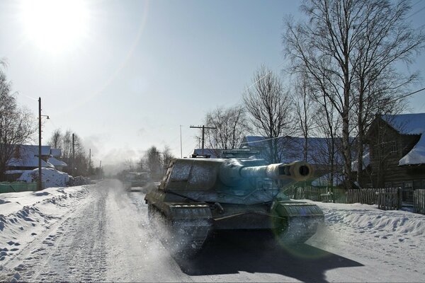 In winter, a tank passes through the village on the road