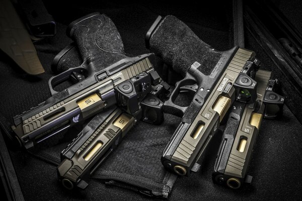 Four black pistols are lying