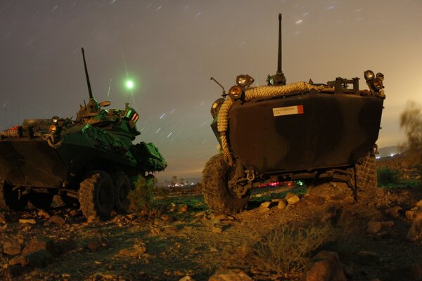 Military vehicles on wheels at night