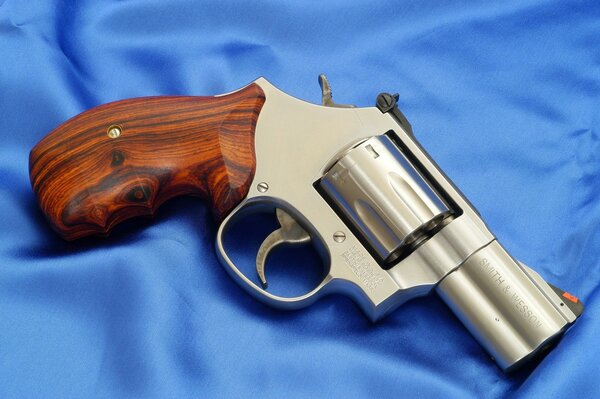 Revolver mit Holzgriff auf blauem Satin