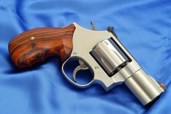 Revolver con manico in legno su raso blu