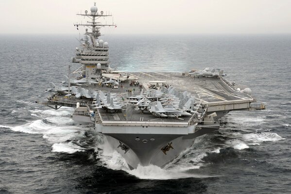 A huge aircraft carrier floats on the water