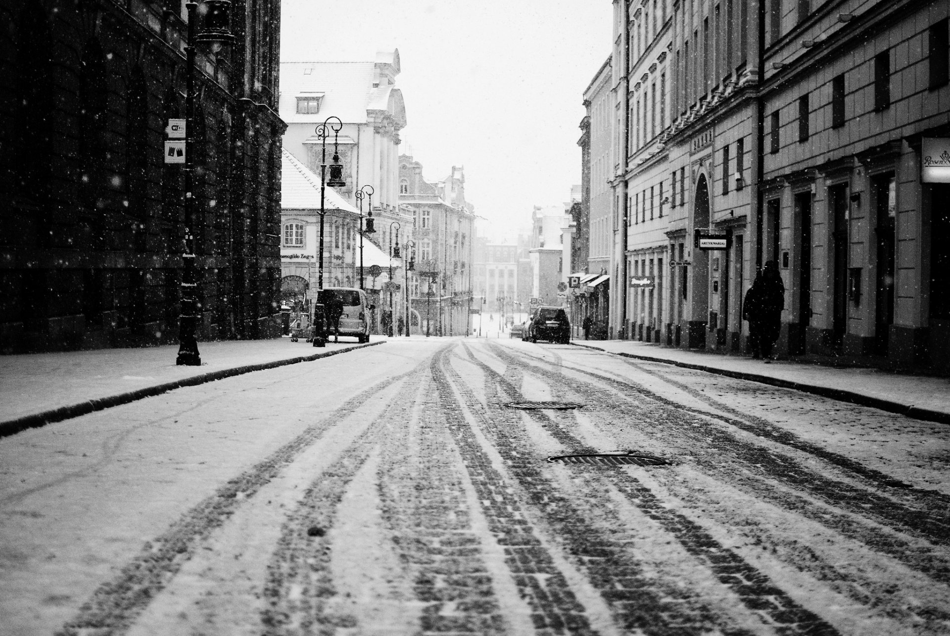 town road snow street buildings house people machinery traces winter