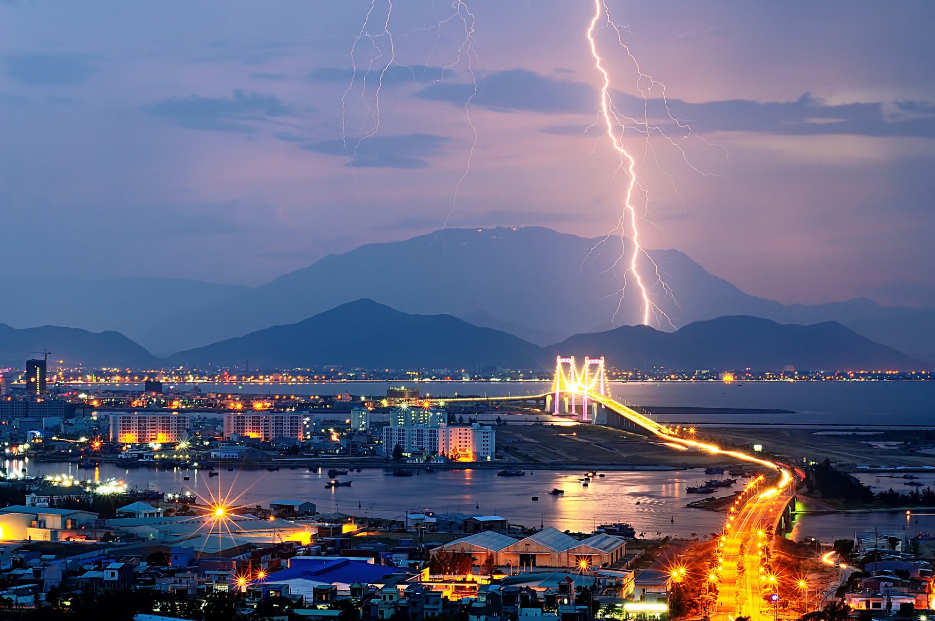 ciudad noche luces montañas relámpago