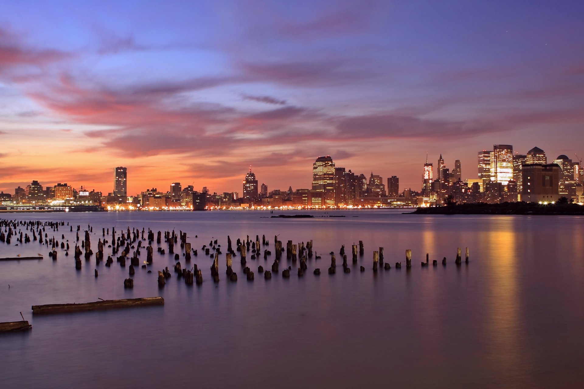 états-unis jersey city new jersey new jersey soirée orange coucher de soleil lilas ciel nuages gratte-ciel rétro-éclairage lumières rivière hudson en bois piliers