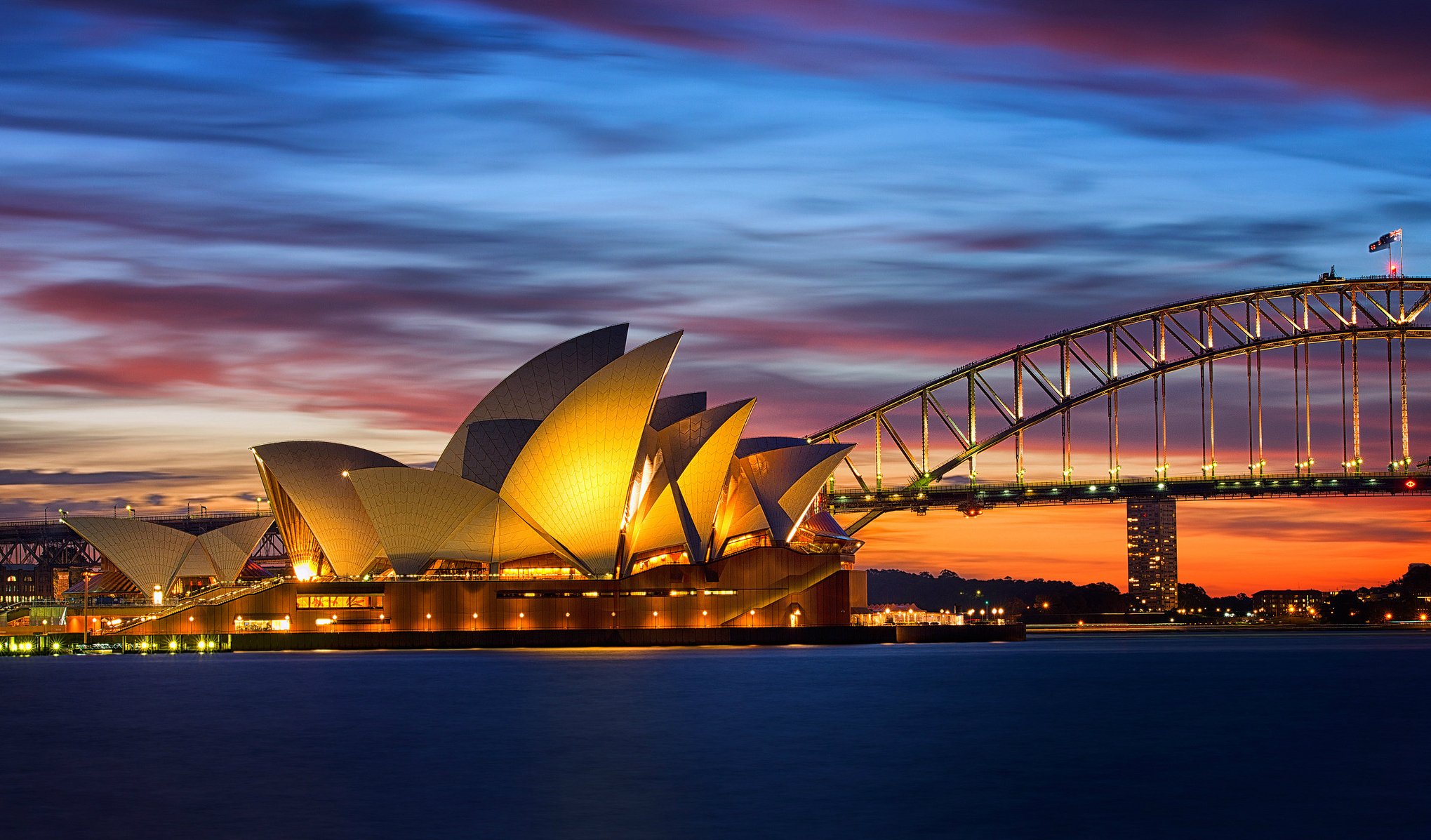 australia sydney casa de la ópera puente noche luces iluminación naranja puesta de sol cielo nubes bahía mar