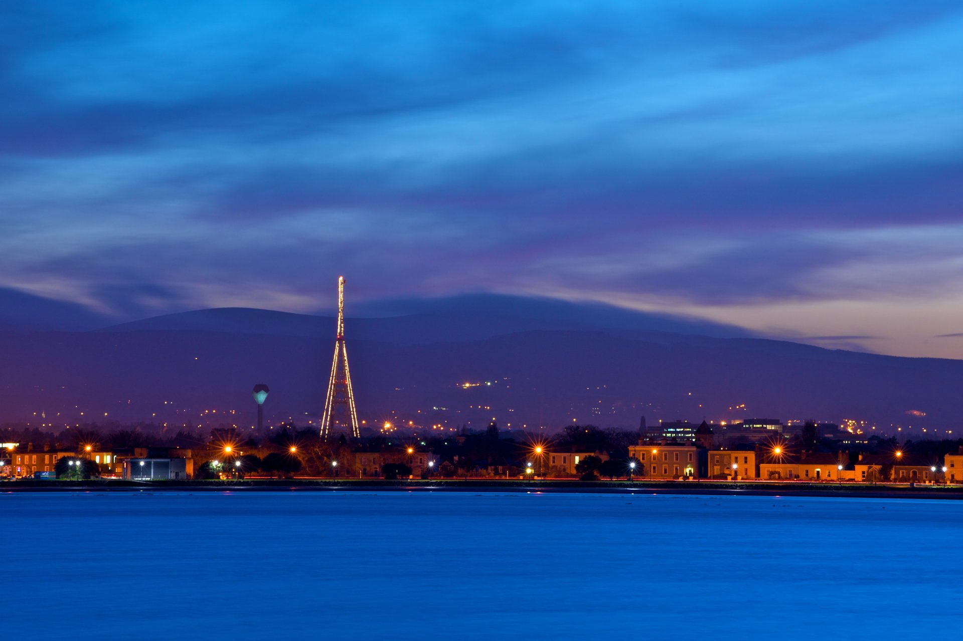 irland dublin hauptstadt hauptstadt abend dämmerung himmel blau wolken berge haus licht lichter laternen uferpromenade fluss