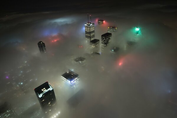 Los rascacielos canadienses y las luces de la ciudad se ven a través de las nubes nocturnas